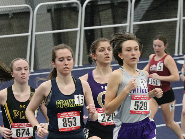 Group of women's track & field runners competing for position.