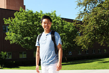 Male student walking across campus