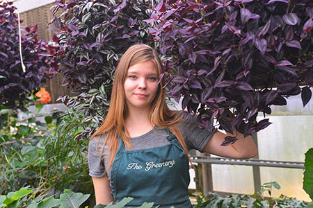 Smiling girl in the greenhouse at SCC.