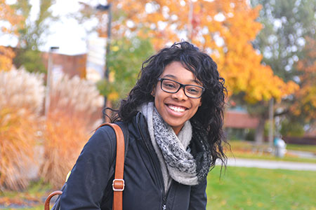 SFCC student with glasses smiling at the camera, outdoor shot